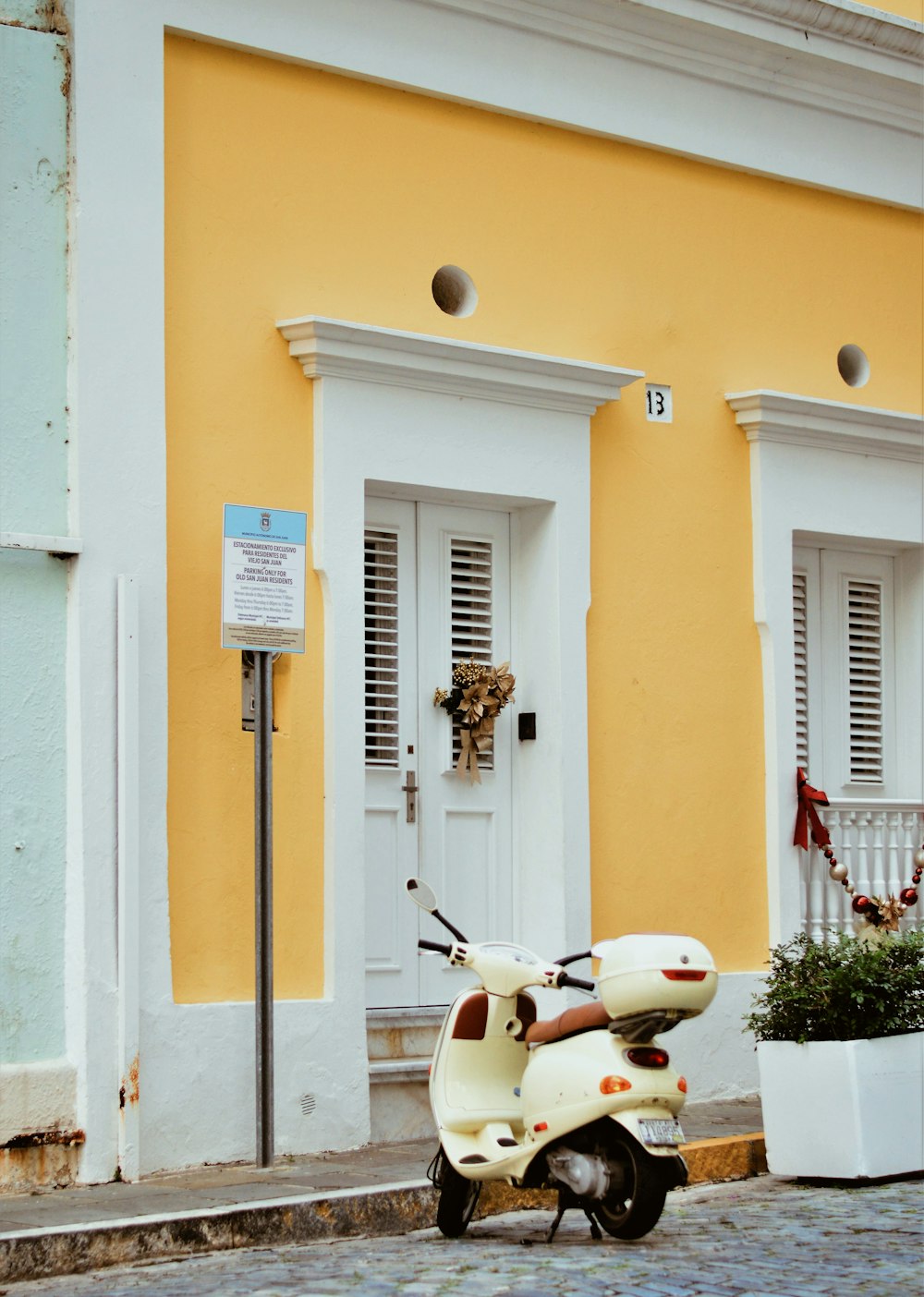 white motor scooter park in front of door house