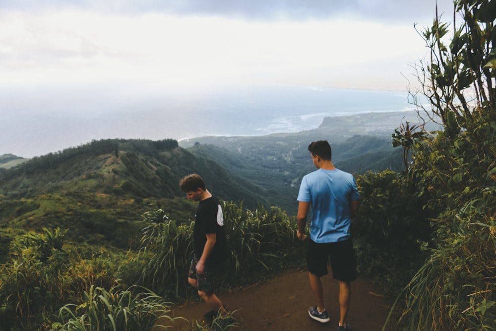 two men hiking on hill during daytime