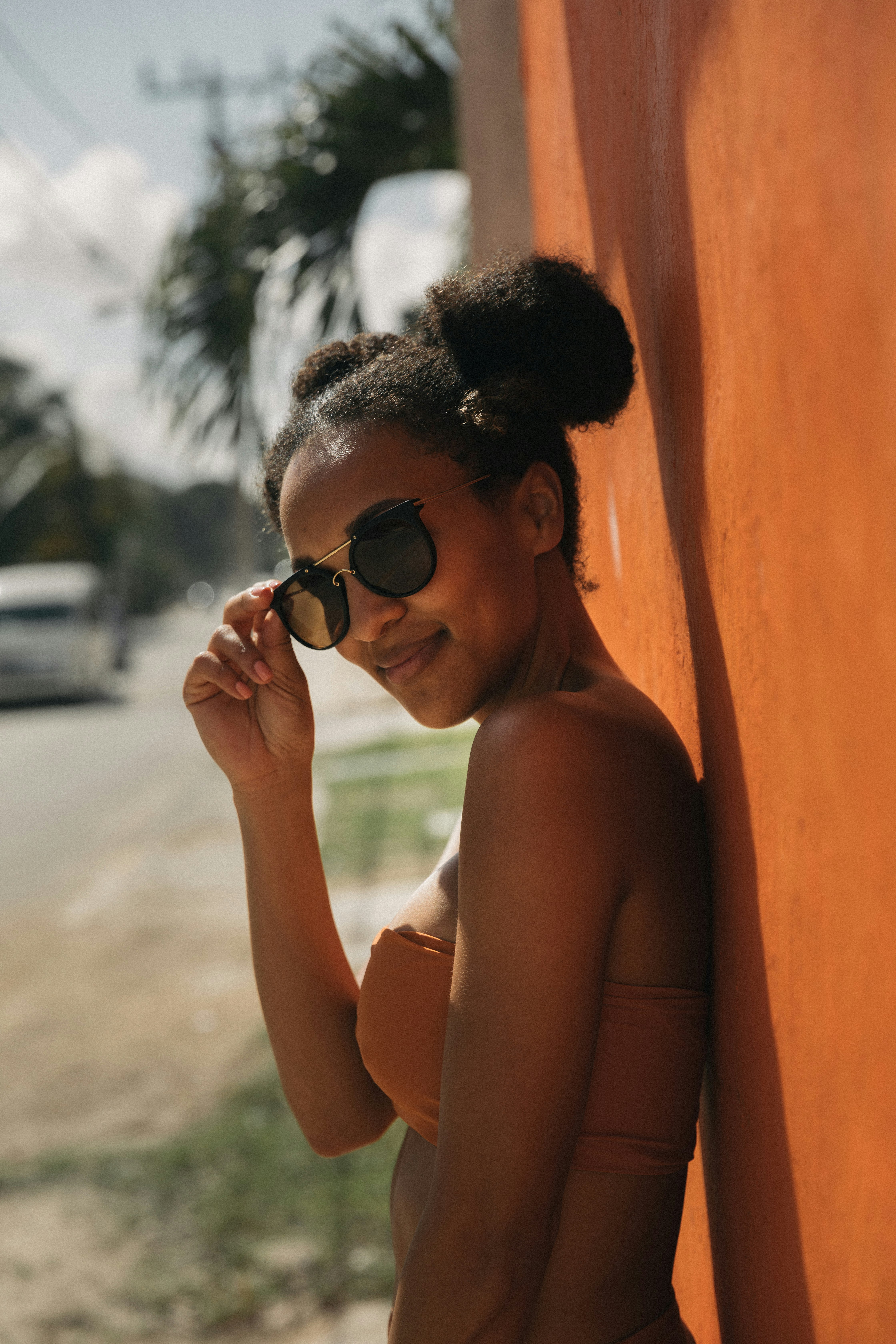 woman in brown bra leaning on wall