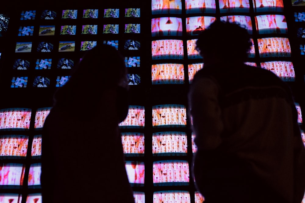 silhouette of two person standing near light