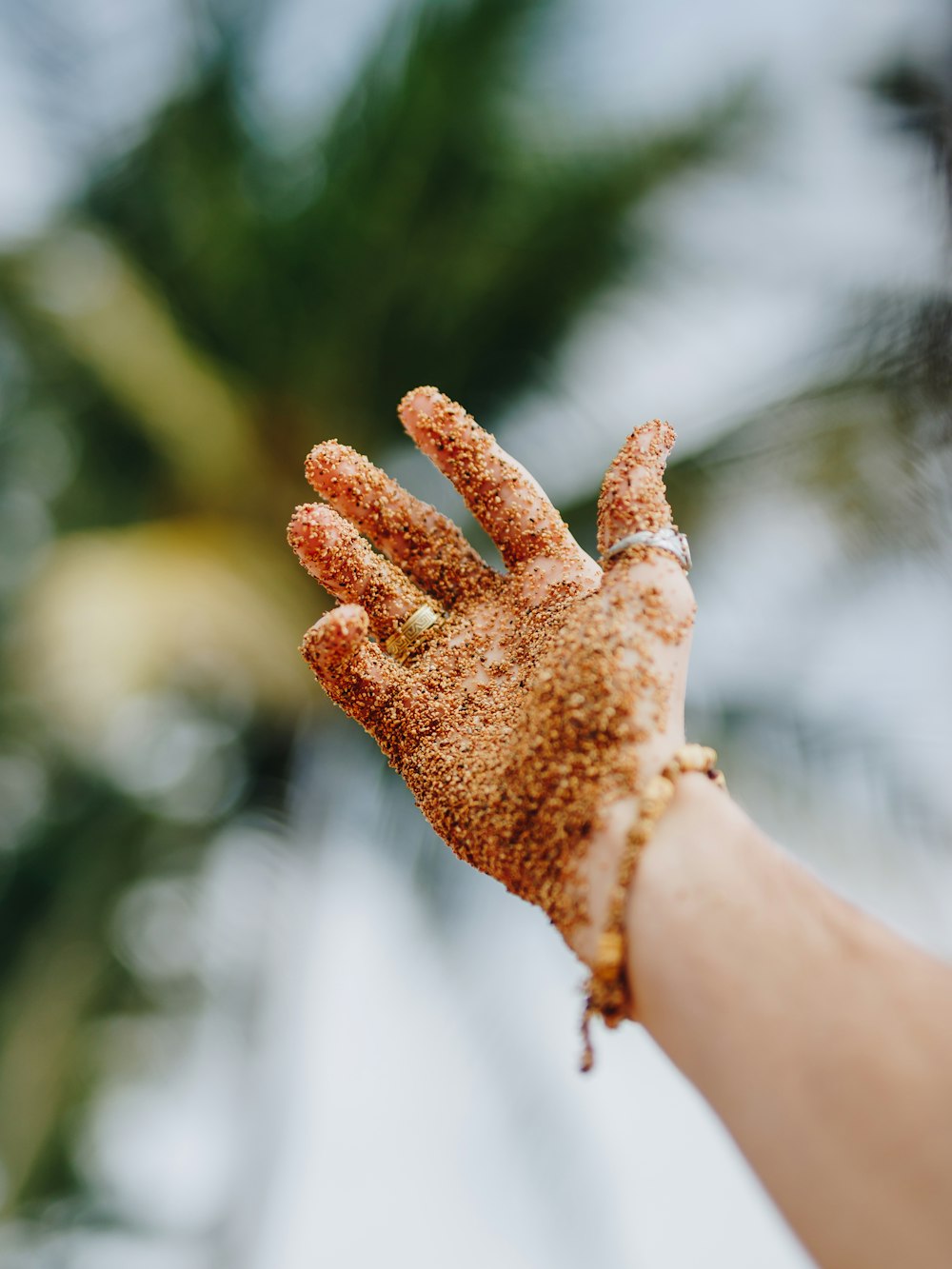 selective focus photography of person raising hand covered with brown powder