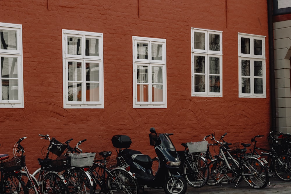 lots of bicycles on park beside red building