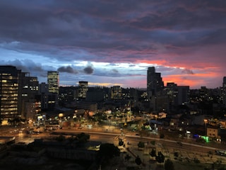 A vibrant Riyadh cityscape at sunset with modern buildings and bustling streets.