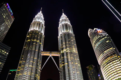 Night view of the twin towers illuminated, highlighting the glass façade.