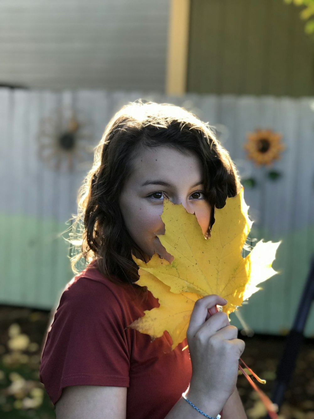 Femme en chemise rouge sentant la feuille d’érable jaune