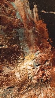 A detailed view of brushstrokes in burnished gold and softened ochre on a matte canvas.