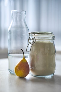 clear glass jar near glass pitcher