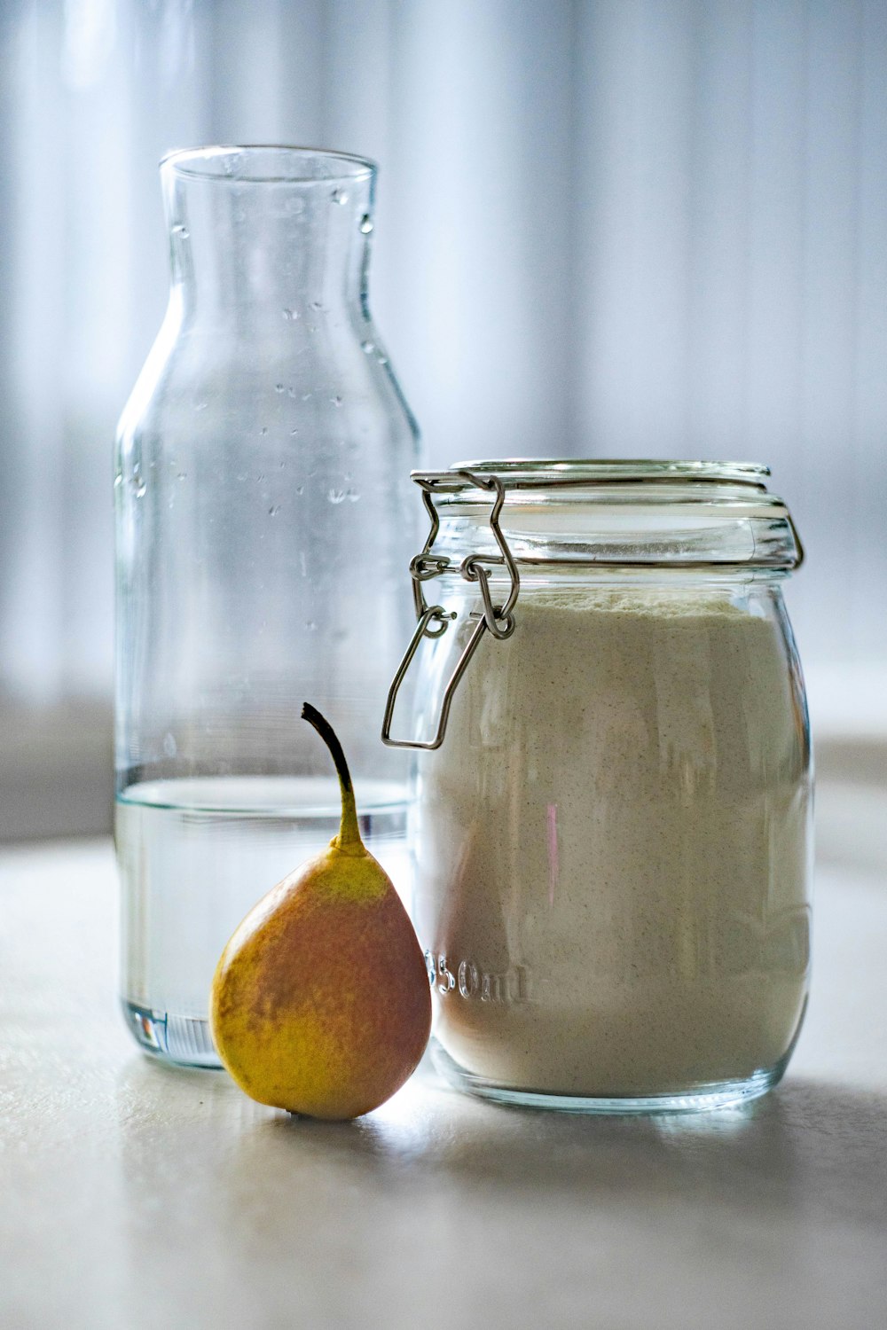 clear glass jar near glass pitcher