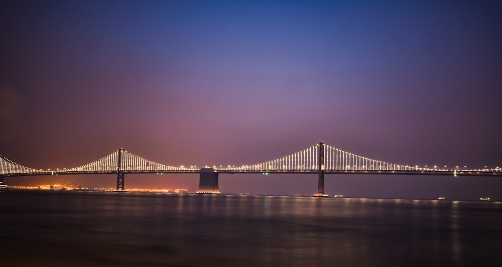 suspension bridge with lights during golden hour