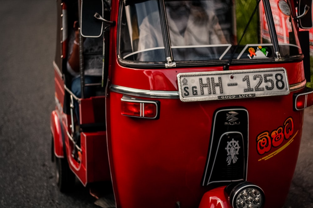 red and black Bajaj auto-rickshaw