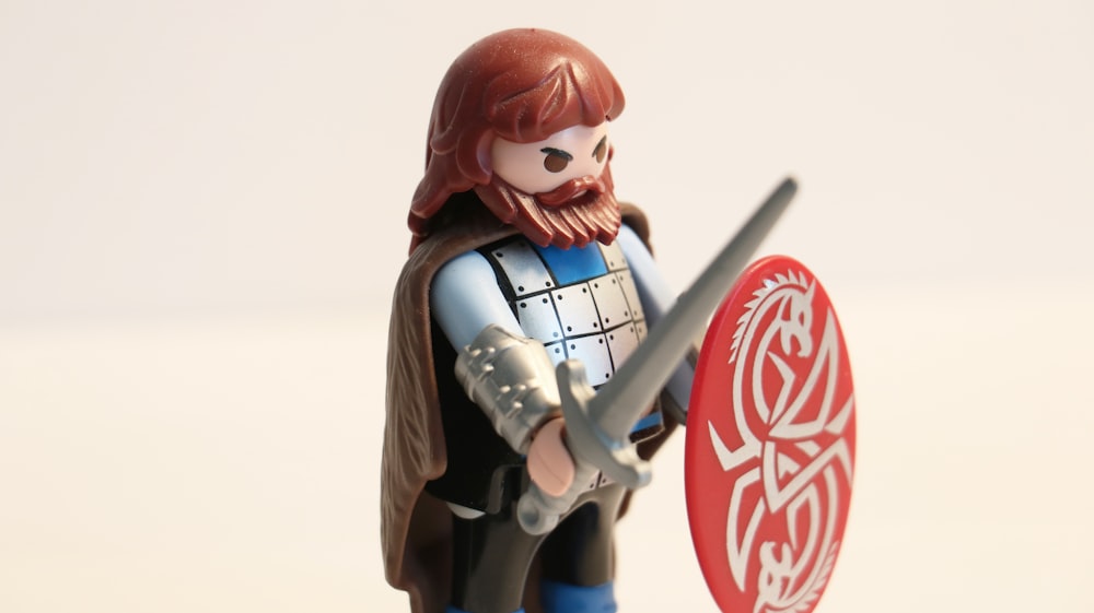 Hombre con barba larga mientras sostiene la espada y el escudo minifig