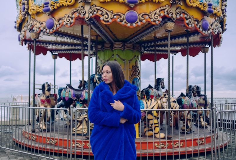 woman wearing blue coat near carousel