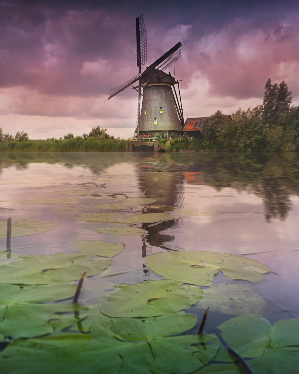 grey wind mill near lake during daytime