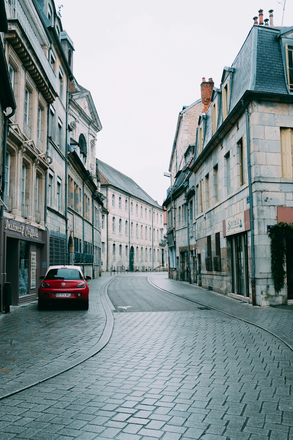 red car parked near houses during daytime