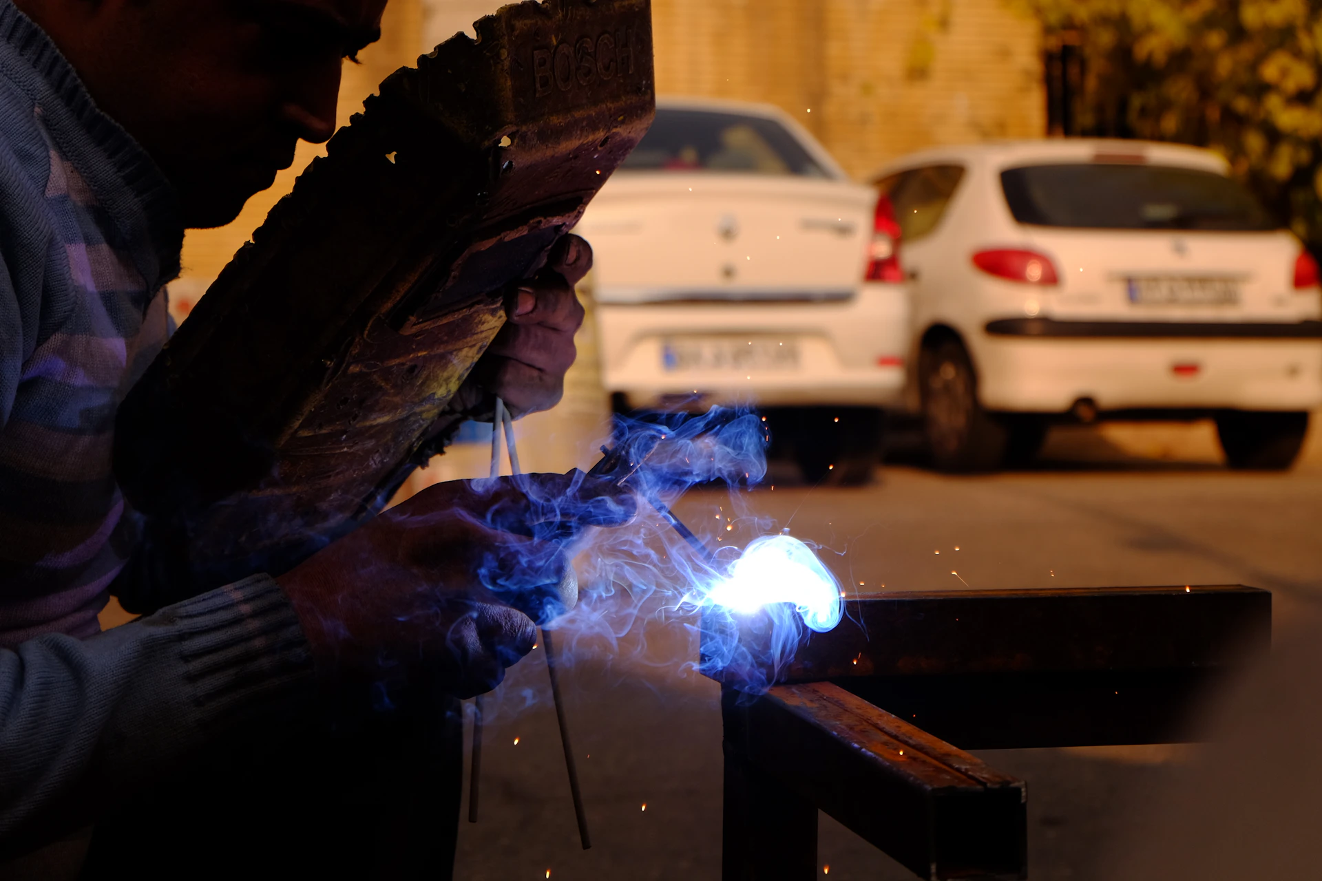 person doing welding on metal bar