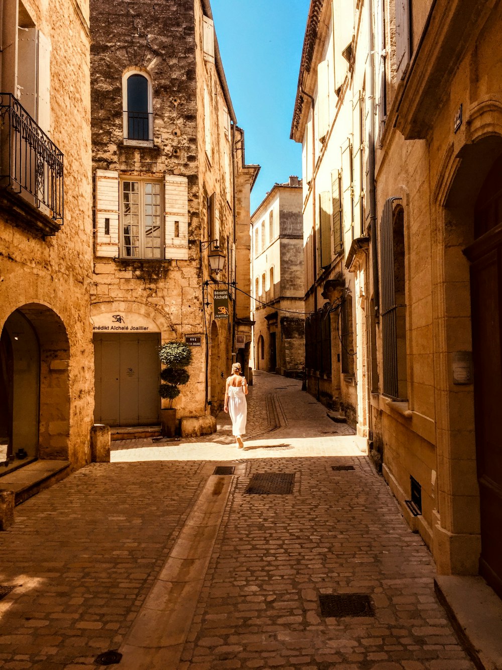 woman walking on narrow pathway during daytime