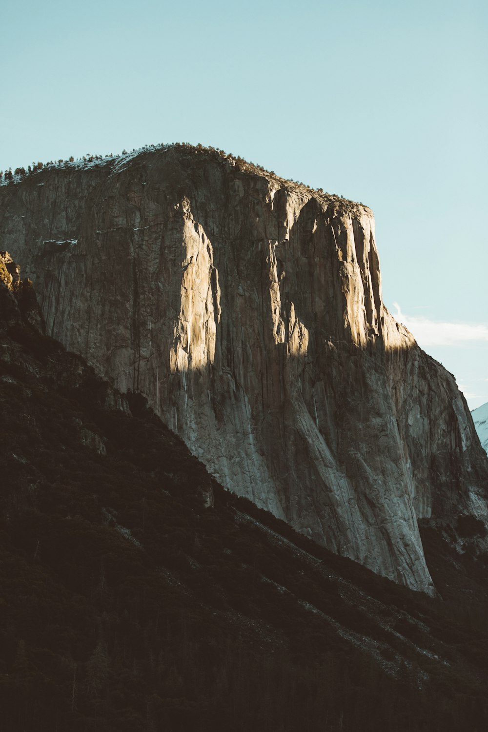 brown rock formation under blue clouds