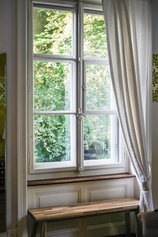 A rustic wooden bench resting by a window, glowing softly in natural daylight.