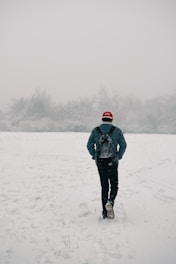 man walking on snow field