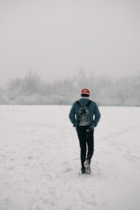 man walking on snow field
