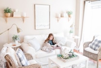 girl seated on sofa reading book