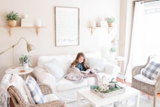 girl seated on sofa reading book