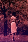 A model walking through a quiet park wearing muted blue and earthy tones.