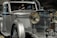 A vintage luxury car with a silver finish, featuring a prominent front grille and large round headlights. The vehicle showcases a classic, elegant design with intricate detailing.