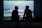 silhouette of man and woman sitting on ottoman