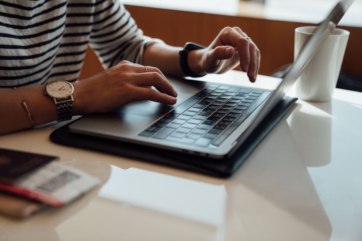 woman wearing striped shirt working on a laptop