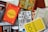 A collection of books is arranged haphazardly on a flat surface. The books are of various colors and titles, including 'The Alchemist,' 'The Best Places for Everything,' and 'You Are a Badass.' Some books are stacked on top of others, showing a mix of orientations with some covers facing up and others showing their spines.
