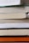 A close-up of a stack of colorful printed books on a wooden table.