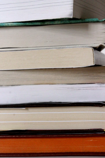 Close-up of a stack of Abby Turkson's books with colorful covers arranged on a wooden table.