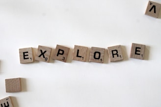 flat lay photography of scrabble tiles forming explore word