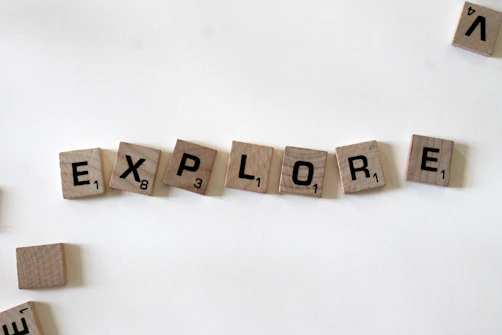 flat lay photography of scrabble tiles forming explore word