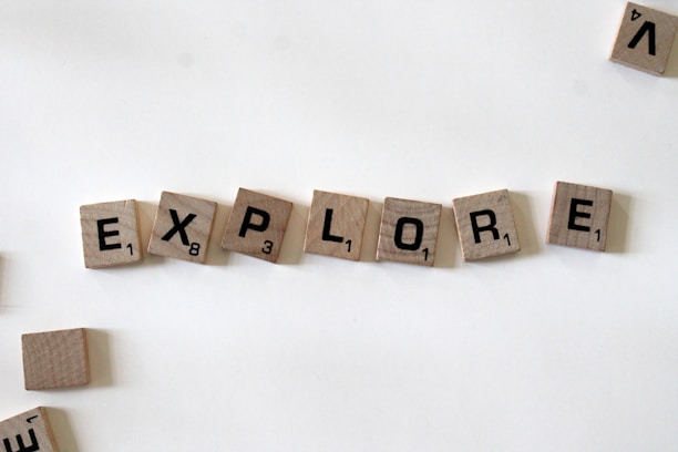 flat lay photography of scrabble tiles forming explore word
