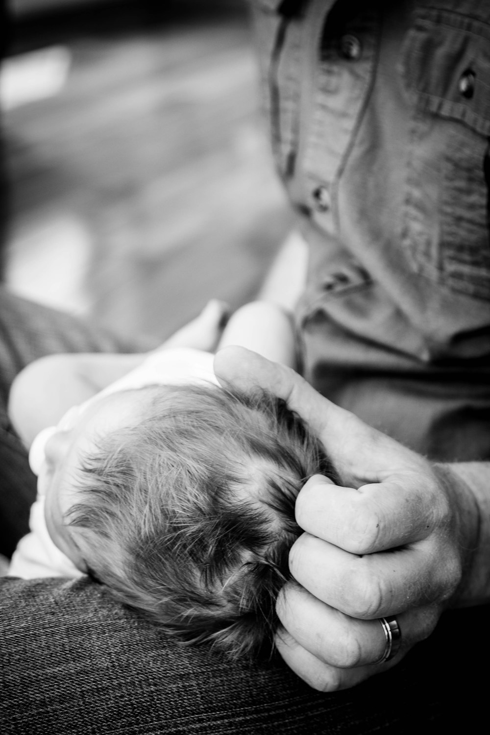 person with baby on her lap in grayscale photography