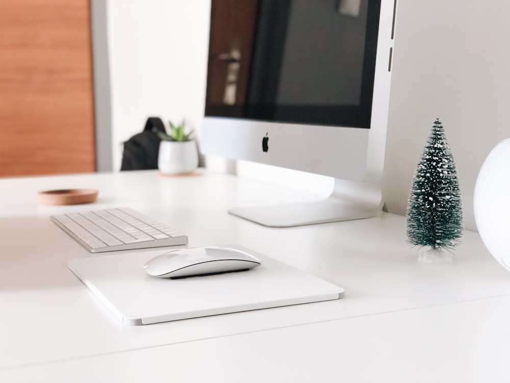 Monitor Apple desligado ao lado do teclado e mouse Apple