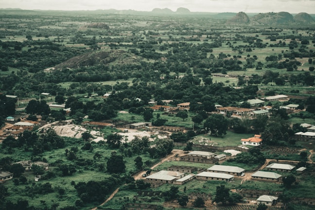 Aerial shot of a cluster of elegant countryside homes nestled among trees and rolling hills.