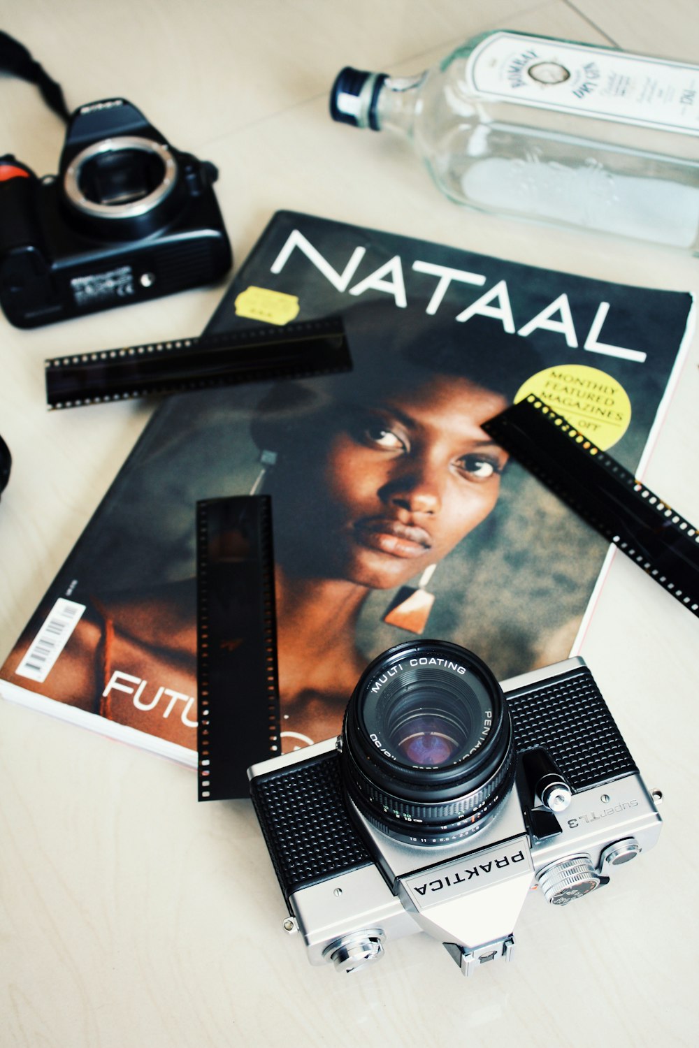 gray and black DSLR camera on top of Nataal magazine