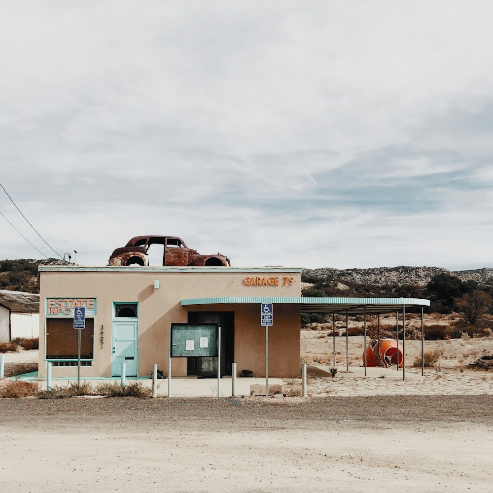 classic wrecked vehicle on top of beige concrete house during daytime