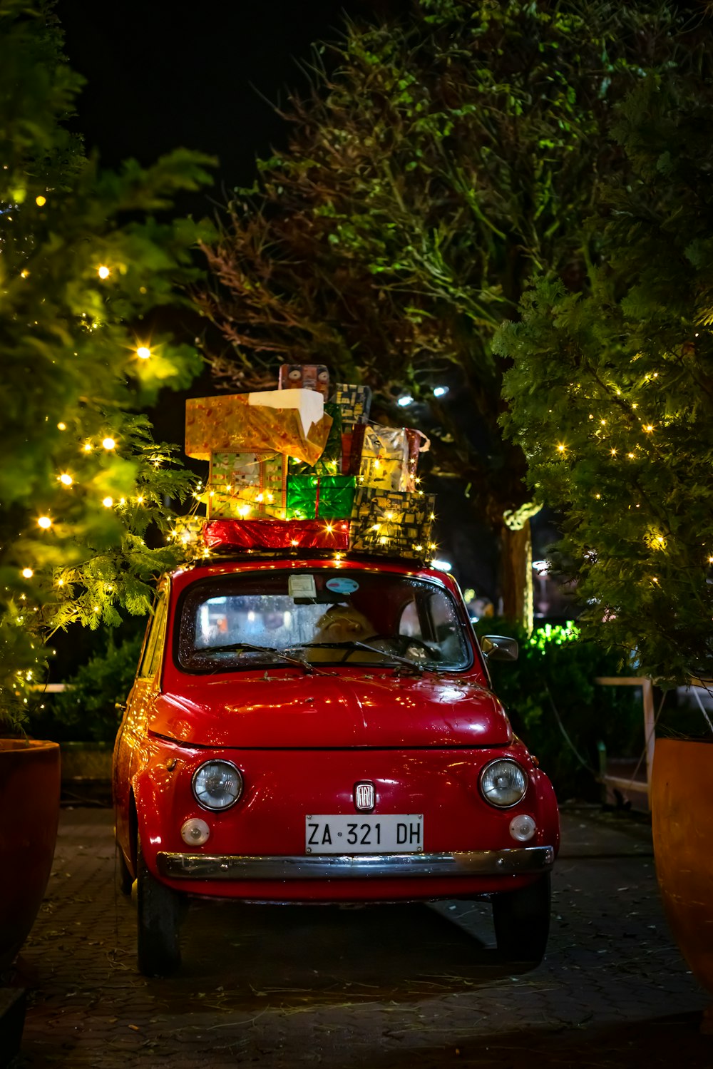 FIAT 500 rojo clásico con cajas navideñas en la parte superior