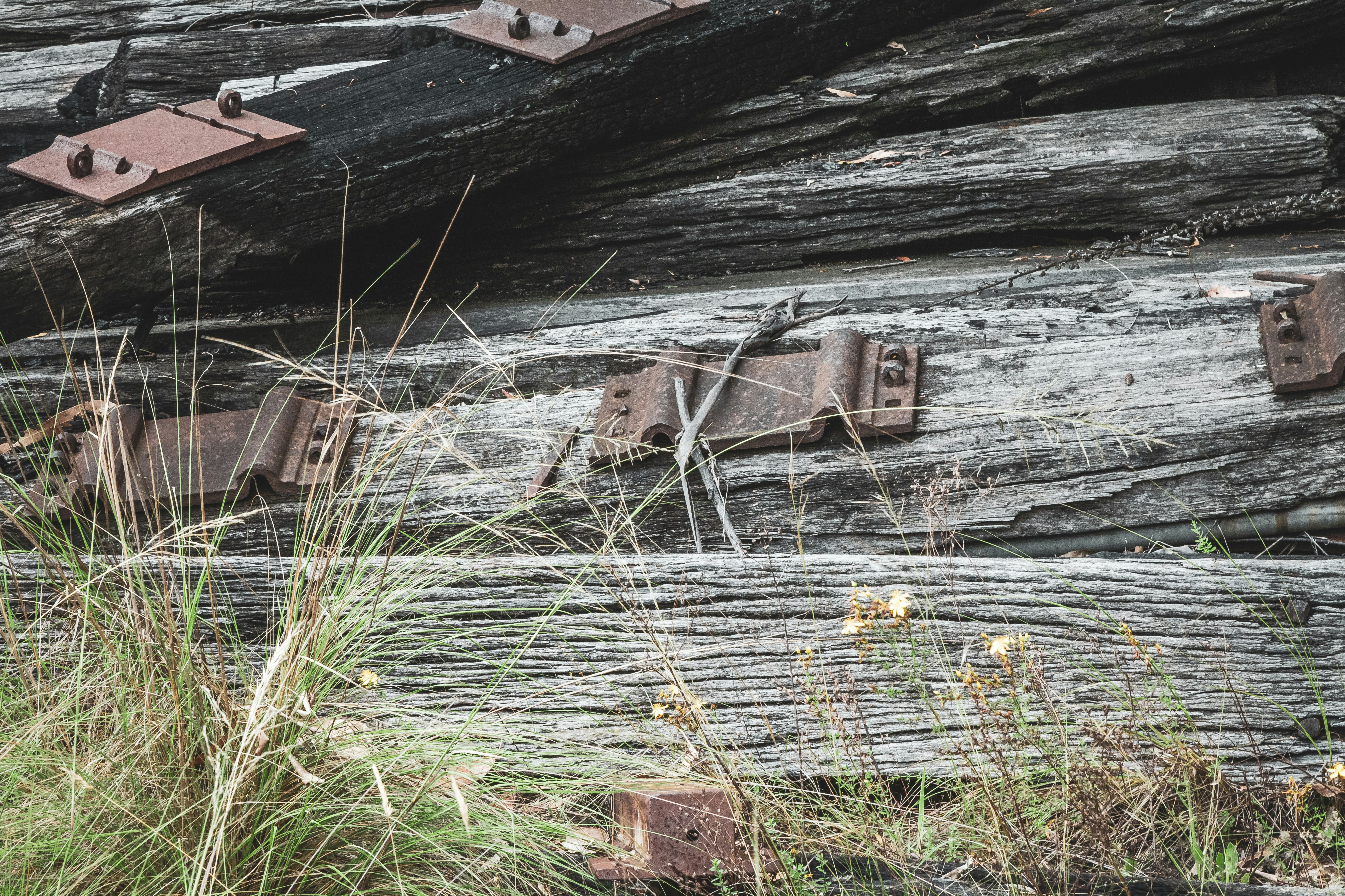 Railway wooden sleepers stacked in timber yard, natural wood grain, overcast industrial lighting