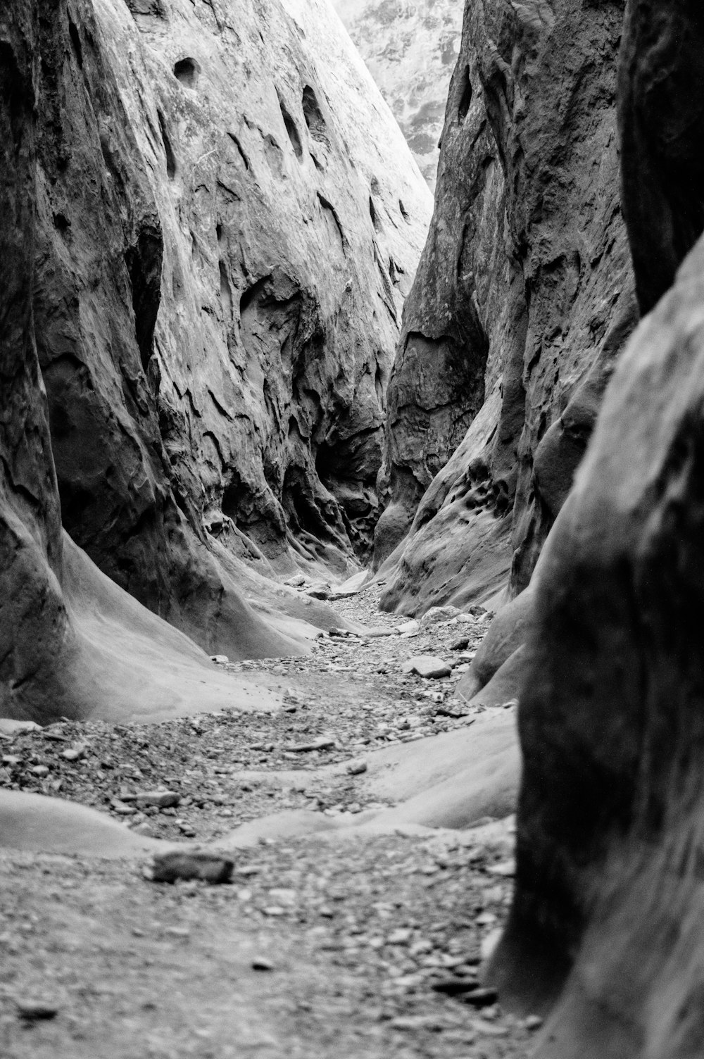 grayscale photo of pathway in middle of hills