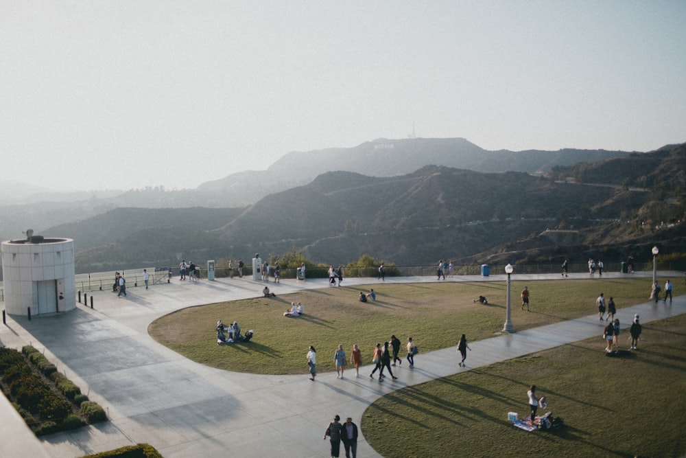 aerial photography of people around open field near mountains