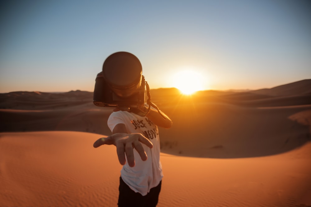 man with camera in desert during dusk