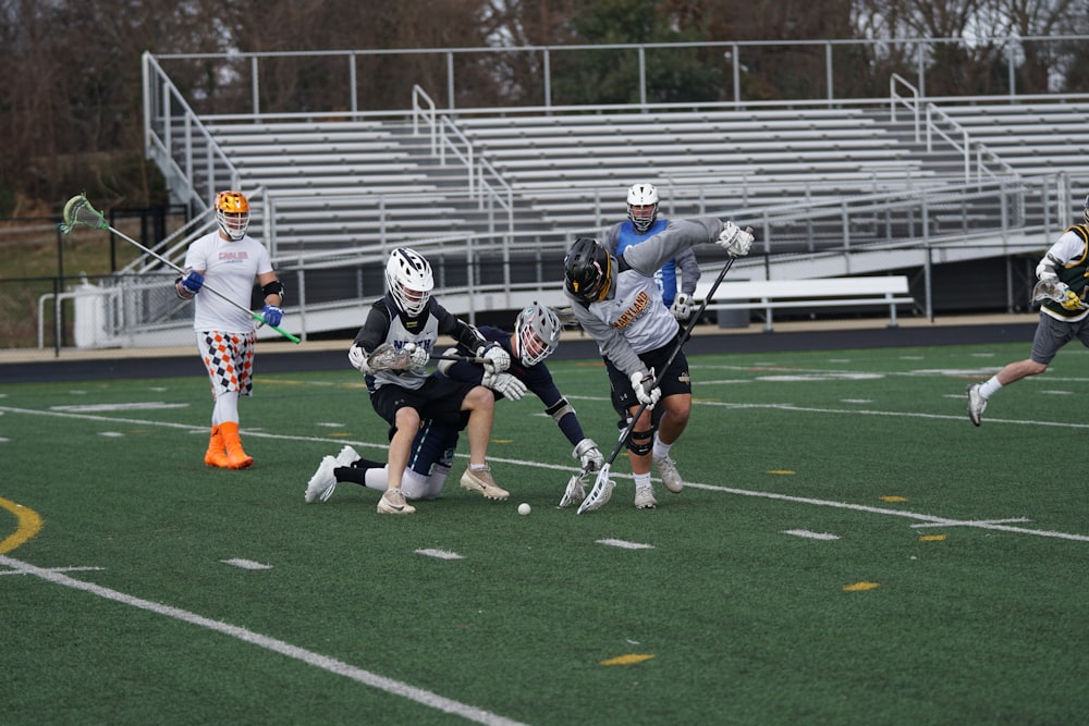 men playing lacrosse in field