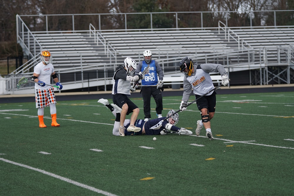 four men playing field hockey