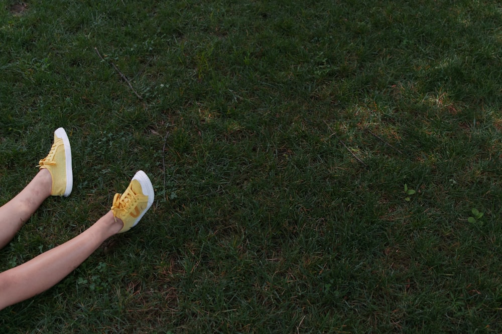 Person in gelben Schuhen auf Gras