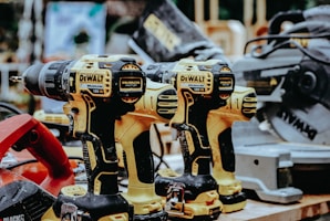 yellow Dewalt hand drills on table
